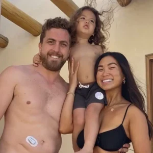 man wearing dexcom g6 while taking a family photo after swimming