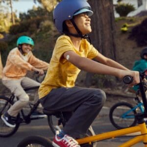 boy riding bike with friends while wearing the freestyle libre for kids
