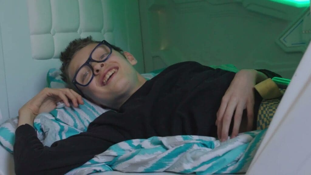 boy smiling while laying in zpods bed